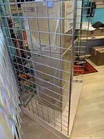 Close-up image showing the wire grid structure and metal welds of the panel with a light wood base visible below.