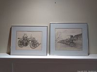 Two framed drawings displayed side by side on a ledge showing an 1878 Silsby steamer and a steam engine train.
