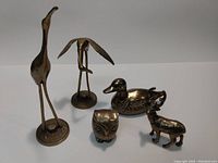 Group image showing all five brass animal figures together on a flat surface