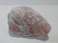 Photo of a large pink quartz rock approx 6 inches in size showing natural crystalline textures and pink coloration.