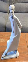 Front view of Lladro Doctor porcelain figurine showing a tall, slender man with glasses and mustache wearing long coat and standing with hands behind back.