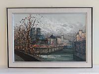 Full view of the framed oil painting showing a waterside city scene with trees and buildings