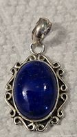 Close-up front view of pendant showing blue lapis lazuli stone in detailed sterling silver setting.