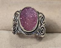 Front view of the sterling silver ring with oval pink druzy stone showing detailed stone texture and silver rope bezel.