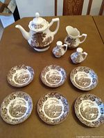 Photo showing full set arranged on table including coffee pot, creamer, salt and pepper shakers, and six fruit bowls.