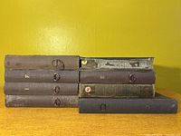 Stack of eight vintage record albums with cloth-bound hardcover covers labeled with letters and numbers, showing general wear consistent with age
