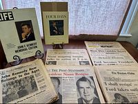 Photo showing the 'Four Days' Kennedy book in its original box, LIFE magazine JFK Memorial edition, and Rocky Mountain News Kennedy issue along with a selection of Nixon resignation and Ford presidency newspapers.