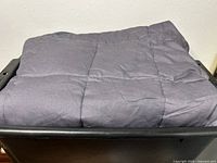 Folded weighted blanket in dark gray with stitching detail visible