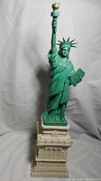 Front view of 16-inch Statue of Liberty replica with green statue and beige pedestal base on a white background.
