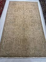 Full view of entire rug laid flat showing overall beige floral design