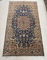 Full view of rug laid flat on floor showing overall pattern and condition