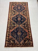 Full view of rug laid flat showing three medallions and rust border