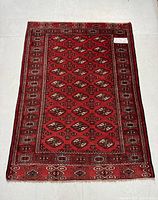 Full view of rectangular rug displaying geometric gul pattern and border