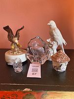Lot of 5 bird-themed decorative figurines and paperweight displayed on black surface against red background