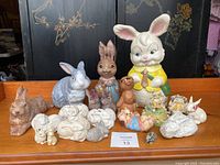 Full lot of assorted bunny figurines displayed on wooden surface for overview