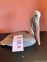 Front and side views of the wooden pelican decoy showing detailed painting and sculpting.