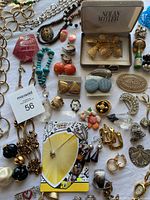 Close up of assorted brooches, earrings, pins, and beaded necklaces showing colors and textures.