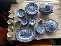 Overhead view of full lot including mugs, plates, bowls, platter and tureens