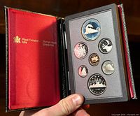 The complete 1986 Canadian proof coin set displayed in foam within a black case with red satin lining and Royal Canadian Mint branding inside the lid.
