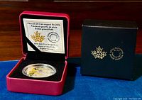 Closed red velvet display box with Canadian mint logo on black outer box