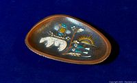 View of triangular pottery dish showing detailed Inuit symbolism design with bear, sun, and abstract shapes in earthy colors.