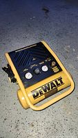 Front view showing Dewalt branding, dual pressure gauges, and control knob.