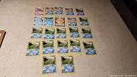 Photo showing majority of the 22 Pokémon cards laid out flat on a surface, mainly water type Pokémon with yellow borders, including Krabby and Horsea cards.