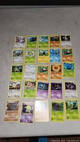 Flat layout photo of all 25 Pokémon cards showing front artwork and details on a gray background.