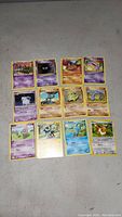 Full layout of 12 assorted Pokémon cards including Psychic, Fighting, and Water types with detailed artwork and yellow borders.