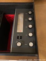 Close-up photo of the control panel showing tuner display, and knobs for tuning, balance, treble, bass, volume, and a power switch with labels for phono, AM, FM.