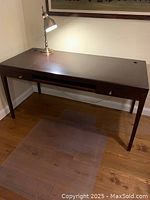 Solid hardwood espresso computer desk shown from front with lamp on top, showing condition and drawers closed.