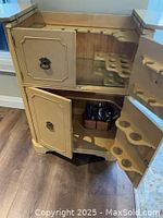 Open interior view showing upper and lower cabinet compartments, internal bottle storage racks, bottle slots on doors, and glass holder slots under top side panels.