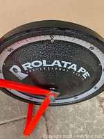 Close-up of the solid steel disk wheel with measurement units and ROLATAPE brand name.