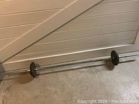 Full view of vintage York barbell with weights on each end, placed on floor