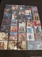 Full layout of the 30 sealed brand new CDs spread on a floor showing front covers of various rap, hip hop, R&B albums.