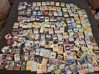 Wide layout of many trading cards on a surface showing multiple Pokemon cards from various editions including legendary and basic Pokemon.