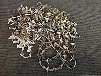 Photo showing a large pile of Southwestern fetish necklaces with carved animal pendants and heishi beads in natural earthy tones.