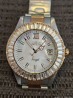 Front view of the Invicta Angel wristwatch showing white dial, Roman numerals, crystal bezel, and date magnifier
