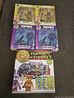 Photo of all figures including 2 Jonesy Fortnite, 2 Dark Bomber Fortnite, and Five Nights at Freddy's stage set with multiple figures