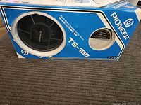 Box with the speaker visible through the protective grille, showing the Pioneer logo and model TS-168.