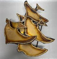 Photo of boho brass fish wall sculpture showing stylized fish with burnt edge patina