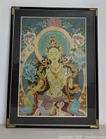 Front view of framed Tibetan Legou silk embroidery showing meditative figure with floral background and detailed colors.