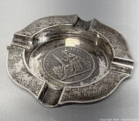 Top view of silver ashtray showing the coin design with a female figure seated on a throne, dated 1895, and the textured outer rim with four cigarette rests.