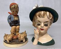 Front view of the Hummel figurine and Inarco lady head vase together showing details and size