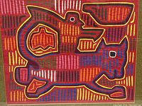 Close-up of the vivid hand-stitched Panama mola textile depicting a cat and bird in multi-colors on red fabric.