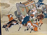 Close-up view of the detailed embroidered silk scene showing figures and animals in traditional Chinese attire with raised textures on silk fabric.