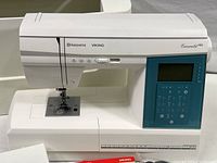 Front view of sewing machine head showing needle, presser foot, and throat plate