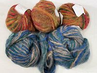 Five yarn skeins shown; three in warm autumn colors and two in blue/gray tones.
