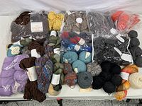 Overhead view of entire yarn assortment showing bagged bundles and loose balls