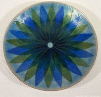 Top view image of the circular enamel on copper plate featuring a blue and green starburst pattern radiating from the center.